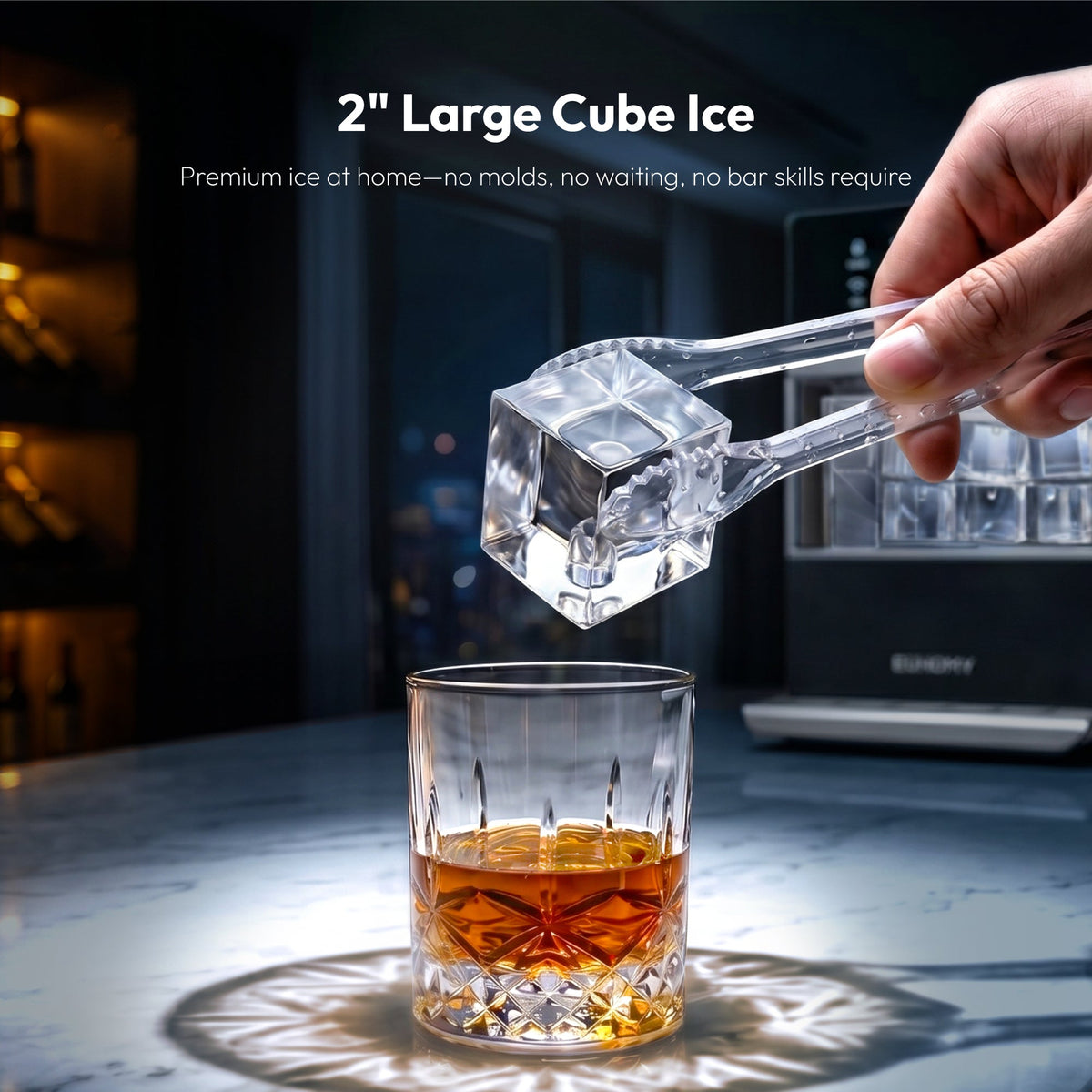 2-inch clear square ice cube held with tongs above a whiskey glass, Euhomy ice maker